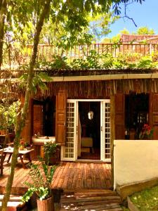 a house with a porch with a door open at Bangalô Maria Eliza, luxo próximo ao mar in Trancoso