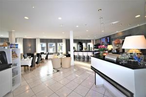 a living room with a kitchen and a dining room at Ascot Hotel in Remscheid