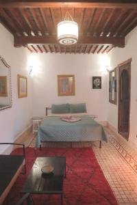 um quarto com uma cama e uma mesa num quarto em Riad Dar Afram em Essaouira
