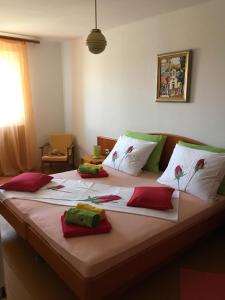 Una cama grande con almohadas rojas y verdes. en Villa Sea Dream Koločep, en Koločep