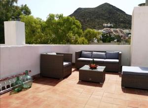 a patio with couches and tables and a view of a mountain at El Playaiso de San José in San José