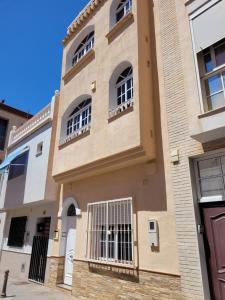 un edificio con ventanas de barrotes en una calle en Apartamento Padilla Playa Huelin en Málaga