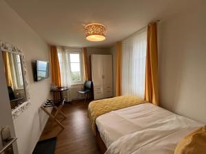 a small bedroom with a bed and a window at Hotel & Restaurant Hasenstrick in Dürnten