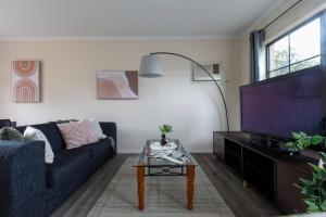墨尔本Heart of McKinnon Units by Ready Set Host的带沙发和电视的客厅