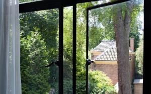 an open window with a view of a tree at Boutique Hotel De Salon in The Hague