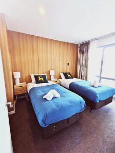um quarto de hotel com duas camas e uma janela em 37 Galaxy A em Lake Tekapo