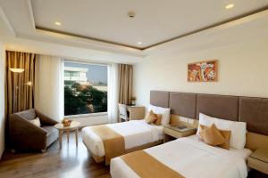 una camera d'albergo con due letti e una finestra di Royale Lalit Hotel Jaipur a Jaipur