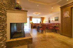 sala de estar con chimenea y comedor en Liebes Caroline 4-Sterne-Hotel en Pertisau