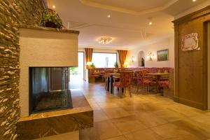 a living room with a fireplace and a dining room at Liebes Caroline 4-Sterne-Hotel in Pertisau
