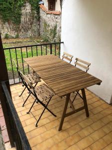 ディエップにあるLe Grand apartment dan Dieppe - Charming home 2-8 guestsの木製テーブル、パティオ(椅子2脚付)