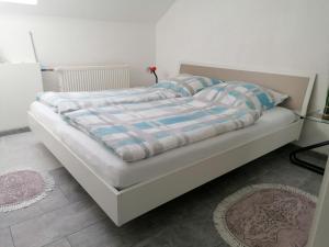 1 cama con edredón y almohadas azules y blancos en Apartment an der Schweizer Grenze, en Laufenburg