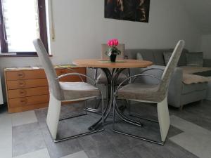 una mesa con dos sillas y un jarrón de flores. en Apartment an der Schweizer Grenze, en Laufenburg