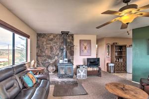 a living room with a couch and a wood stove at Peaceful Ranch Cabin, 3 Mi to Becker Lake! in Springerville