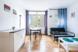 eine Küche und ein Wohnzimmer mit einem Sofa und einem Tisch in der Unterkunft Solaz-Andaluz City Center Apartment in Torremolinos