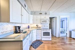 una cocina con armarios blancos y electrodomésticos blancos en Beachfront North Wildwood Condo with Ocean Views!, en North Wildwood