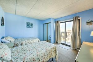 Habitación azul con 2 camas y ventana en Beachfront North Wildwood Condo with Ocean Views!, en North Wildwood