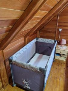 a bed in a room with a wooden ceiling at Kuća za odmor DM in Bajina Bašta
