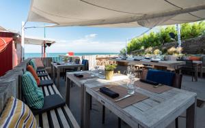 a restaurant with tables and chairs with the ocean in the background at Hôtel Ar Iniz in Saint Malo