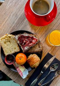 une assiette de pain grillé avec de la confiture et une tasse de café dans l'établissement Hôtel Ar Iniz, à Saint-Malo