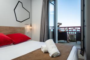 a woman sitting in a chair in a room with a bed at Hôtel Ar Iniz in Saint Malo