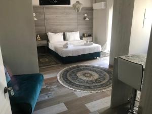 1 dormitorio con cama blanca y alfombra en Ares Suites, en Plataria