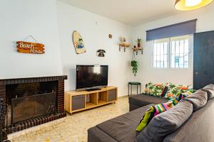 un soggiorno con divano e TV di Casa Vista Alegre Costa el Palmar a El Palmar