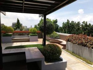 a patio with a bench and bushes on a roof at Mabolo Garden Flats 2306 in Cebu City