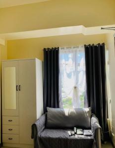 Una sala de estar con un sofá y una ventana. en Mabolo Garden Flats 2306, en Cebú 5 fotos más