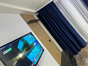 ein Fernseher in einem Zimmer mit einem blauen Vorhang in der Unterkunft Diamond Magic Divcibare in Divčibare