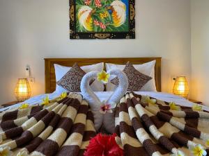 a bed with two swans made out of towels at Pattri Dihati Lembongan in Nusa Lembongan