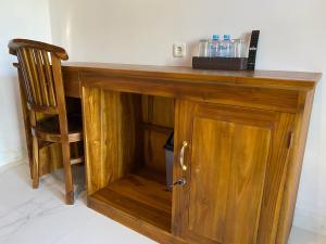 a wooden desk with a chair and a wooden cabinet at Pattri Dihati Lembongan in Nusa Lembongan
