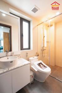 uma casa de banho branca com um WC e um lavatório em Merry House Hoàng Huy Riverside em Haiphong