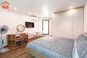 Schlafzimmer mit einem Bett und einem Schreibtisch mit einem Spiegel in der Unterkunft Merry House Hoàng Huy Riverside in Haiphong