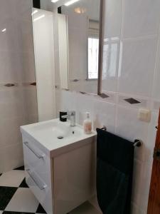 Baño blanco con lavabo y espejo en CASA PACO - Maison Andalousie en Cútar