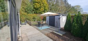 a patio with a table and an umbrella at Sfeervolle recreatiewoning in Putten Veluwe in Putten