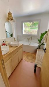 a bathroom with two sinks and a tub and a window at La dolce Giulia in Hyères +21 photos