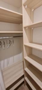 a walk in closet with wooden shelves and shoes at Sfeervolle recreatiewoning in Putten Veluwe in Putten