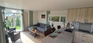 a living room with a couch and a table at Sfeervolle recreatiewoning in Putten Veluwe in Putten