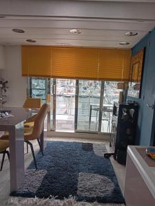 Loc de cabines sur Yacht في جرويسان: غرفة معيشة مع طاولة طعام وطاولة وكراسي