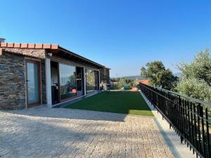 una casa con una valla y un césped verde en Refúgio, en Castelo de Paiva