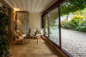 a porch with glass doors and chairs on a patio at Casa do Lameiro in Ponte da Barca