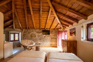 a bedroom with two beds and a wooden ceiling at Casa do Lameiro in Ponte da Barca