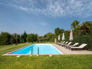 a swimming pool with lounge chairs and umbrellas at Casa do Lameiro in Ponte da Barca