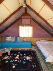 a room with a bed and a rug in a attic at Succah in the Desert in Mitzpe Ramon