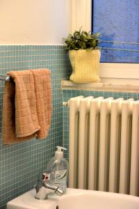 uma casa de banho com um radiador ao lado de um lavatório em Appartamento dei Sassetti em Savona