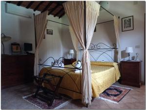 a bedroom with a bed with a canopy at Villino Cortona - Casa vacanze a Cortona con piscina privata WiFi, AC - Toscana - Nelle vicinanze Perugia, Assisi, Montepulciano, Pienza, Siena in Cortona