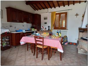 a kitchen with a table with a red and white table cloth at Villino Cortona - Casa vacanze a Cortona con piscina privata WiFi, AC - Toscana - Nelle vicinanze Perugia, Assisi, Montepulciano, Pienza, Siena in Cortona