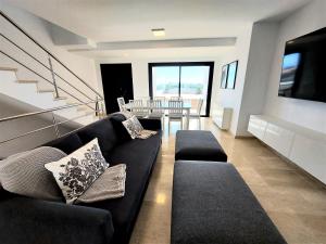 a living room with a black couch and a table at Villa Playa Amadores - Luxury villa with heated pool in Puerto Rico de Gran Canaria
