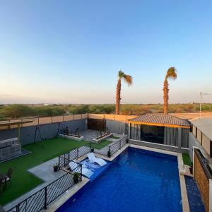 an aerial view of a house with a swimming pool and palm trees at Aroma Mountain Dead Sea in Sowayma