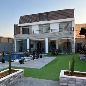 a large house with a yard with green grass at Aroma Mountain Dead Sea in Sowayma